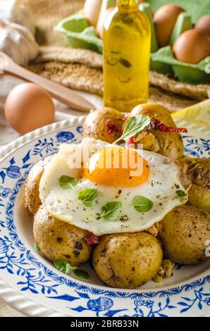 Baked potato with chili and fried egg, fresh young tomatoes and spicy chilli with herbs, great combination of flavours and spicy. Stock Photo