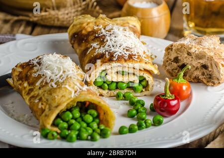 Full protein breakfast, omelette with peas and little parmesan cheese and whole grain baguette, glass of beer Stock Photo