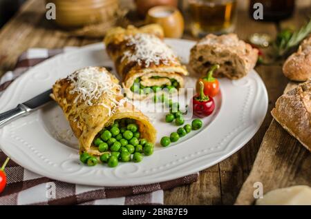 Full protein breakfast, omelette with peas and little parmesan cheese and whole grain baguette, glass of beer Stock Photo
