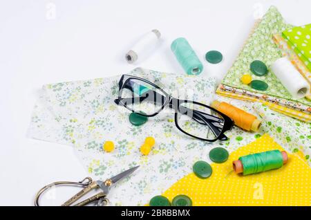 Sewing set with fabric, spools of thread, scissors and glasses Stock Photo