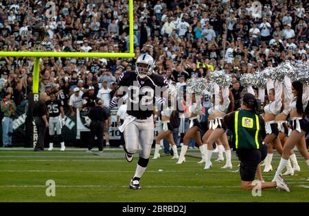 Oakland, California, USA. 16th Nov, 2003. Oakland Raiders full back Zack  Crockett (32) runs for a touchdown with Minnesota Vikings defensive back  Corey Chavous (21) on Sunday, November 16, 2003, in Oakland