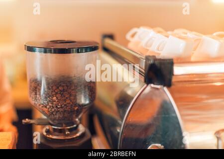 Coffee beans in the coffee mill with white cups. Artistic coffee shop background Stock Photo