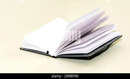 open hardcover notebook on a white table. Unwritten blank pages. Stock Photo