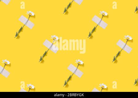 Creative pattern of chamomiles flowers with patches on yellow background. Top view. Flat lay. Stock Photo