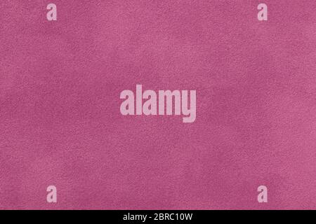 Dark purple matte background of suede fabric, closeup. Velvet texture of seamless red leather. Felt material macro. Stock Photo