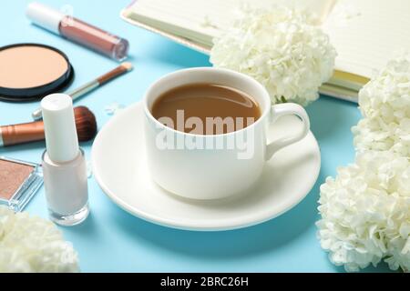 Composition with hydrangea flowers, coffee and cosmetics on blue background Stock Photo