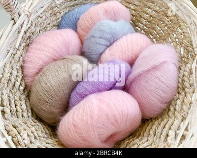 colored balls of wool yarn in wicker basket Stock Photo