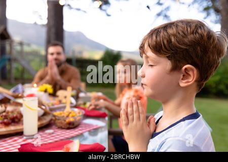 Caucasian family saying grace together before eating Stock Photo