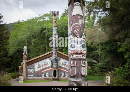 Totem Bight State Historical Park, Ketchikan, Alaska, USA, displays a collection of Native American totem poles and the Wandering Raven clan house. Stock Photo