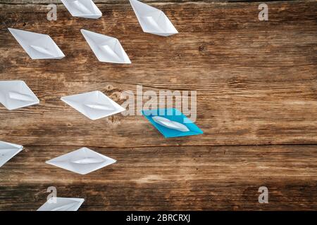 paper boats on aline on the wooden background, concept teamwork, leadership and management Stock Photo