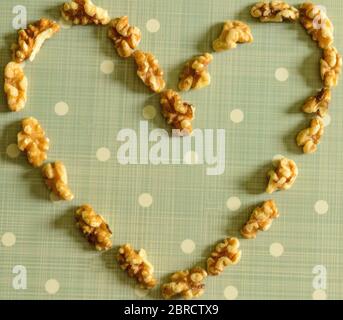 Peeled California Walnut Heart On Blue Background With White Dots Stock Photo