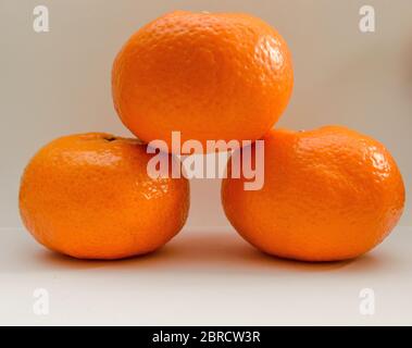Three Tangerines Podium On White Background Stock Photo