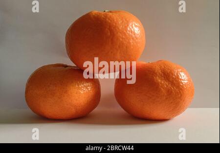 Dark Three Tangerines Podium On White Background Stock Photo