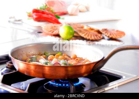 Pan with fish and mussels on gas stove, Germany Stock Photo