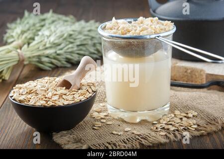 Ingredients and the process of making oats milk or oatmeal beverage at home. Stock Photo