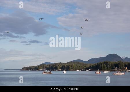 Float planes fly in a v shape display over Ketchikan, Alaska, USA. Stock Photo