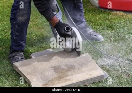 Industrial construction worker using a professional angle grinder Stock Photo