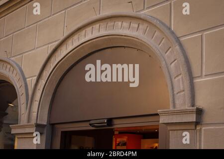 Building with a showcase. Empty plate in the form of an arch on an old house. Empty space for a number, text or store name on glass. Side view from Stock Photo