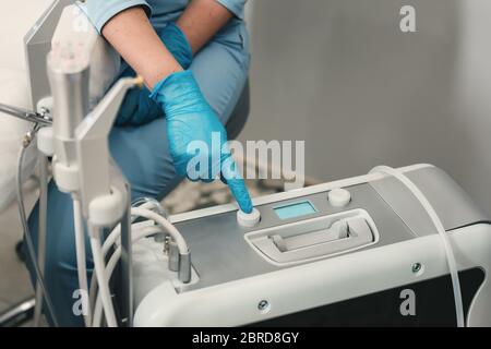 Doctors hand pressing button on a control panel of machine. Medical equipment concept Stock Photo