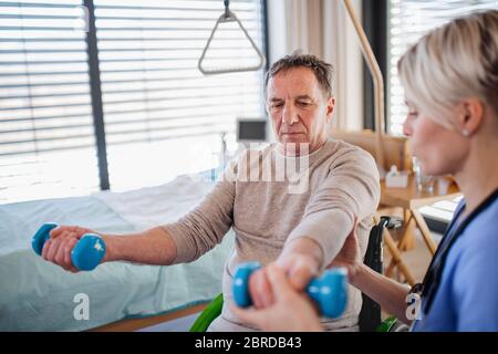 A healthcare worker and senior patient in hospital, physiotherapy. Stock Photo