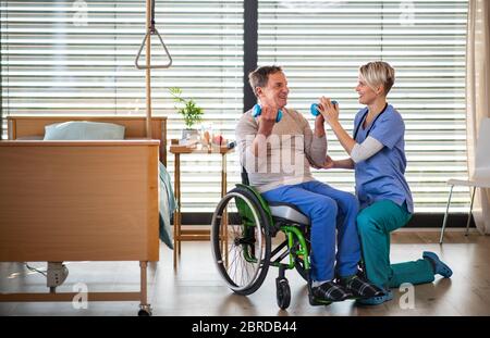 A healthcare worker and senior patient in hospital, physiotherapy. Stock Photo