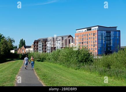 Young couple walking on path along the raised bank of the River Trent, in Gainsborough, Lincolnshire, England UK Stock Photo