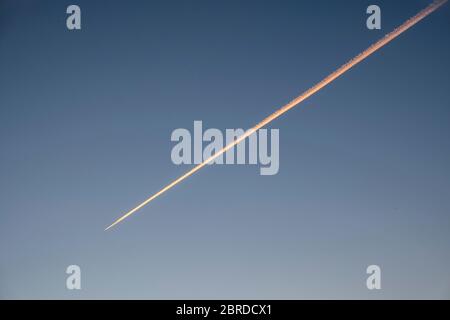 The contrail or vapour trail of a solitary aircraft in an empty sky over the UK during the coronavirus pandemic Stock Photo