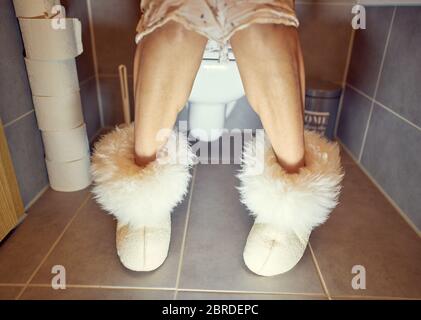 Pfaffenhofen, Germany, 17th May , 2020. Woman sitting on a toilet, with alpaka boots. © Peter Schatz / Alamy Stock Photos Stock Photo