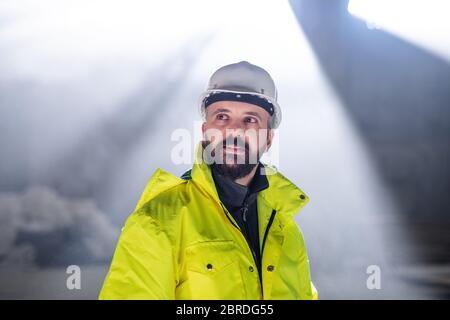Mature man engineer standing on construction site. Stock Photo