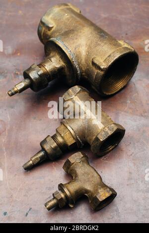 Brass scrap metal: taps, tees, plugs and various plumbing parts, spare  parts. Against the background of a copper sheet. Close-up Stock Photo -  Alamy