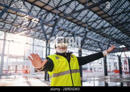 Man engineer using VR goggles on construction site. Stock Photo