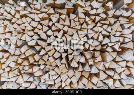 Background of dry chopped firewood logs in a pile. Stock Photo