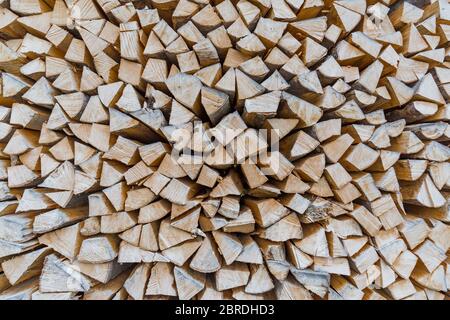 Background of dry chopped firewood logs in a pile. Stock Photo