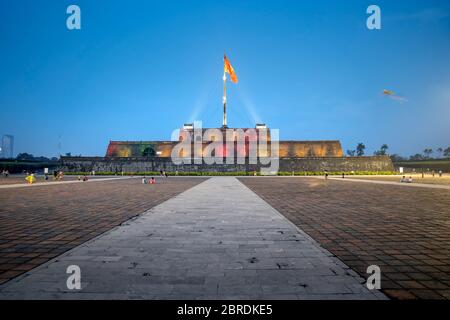 Hue City, Vietnam - May 7, 2020: Amazing view of a square and the flag of Vietnam (red flag with a gold star) fluttering over a tower of the Citadel o Stock Photo