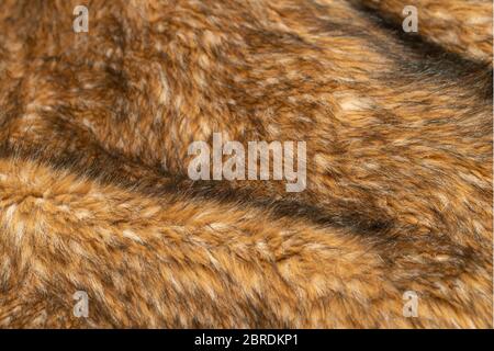 Close-up of a fluffy dark brown faux fur fabric with a background texture. Brown artificial fabric, can be used as a background. Fur for toys or cloth Stock Photo