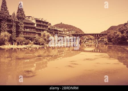 Feng Huang, China -  August 2019 : View of the road bridge over Tuo Jiang river and wooden houses in ancient old town of Fenghuang known as Phoenix Stock Photo