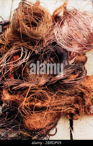 Copper scrap metal, wire, windings of motors and transformers, electrical wire without insulation. Against the background of a copper sheet. Close-up. Stock Photo