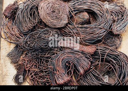 Copper scrap metal, wire, windings of motors and transformers, electrical wire without insulation. Calcined oxidized copper wire. Against the backgrou Stock Photo