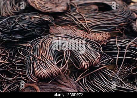 Copper scrap metal, wire, windings of motors and transformers, electrical wire without insulation. Calcined oxidized copper wire. Against the backgrou Stock Photo