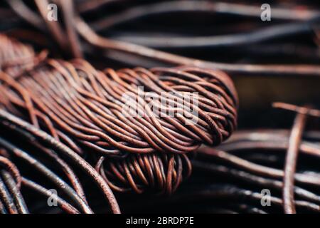 Copper scrap metal, wire, windings of motors and transformers, electrical wire without insulation. Calcined oxidized copper wire. Against the backgrou Stock Photo