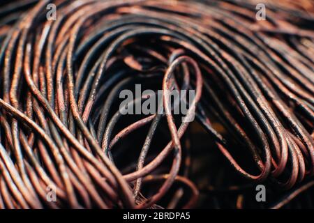 Copper scrap metal, wire, windings of motors and transformers, electrical wire without insulation. Calcined oxidized copper wire. Against the backgrou Stock Photo