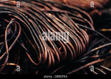 Copper scrap metal, wire, windings of motors and transformers, electrical wire without insulation. Calcined oxidized copper wire. Against the backgrou Stock Photo