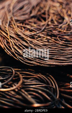 Copper scrap metal, wire, windings of motors and transformers, electrical wire without insulation. Calcined oxidized copper wire. Against the backgrou Stock Photo