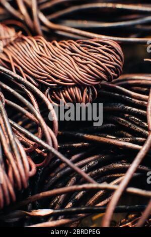 Copper scrap metal, wire, windings of motors and transformers, electrical wire without insulation. Calcined oxidized copper wire. Against the backgrou Stock Photo