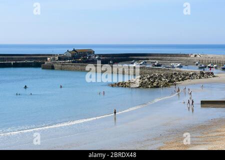 Lyme Regis, Dorset, UK.  21st May 2020.  UK Weather.  Families on the beach paddling in the sea at the seaside resort of Lyme Regis in Dorset on a scorching hot sunny morning.  Picture Credit: Graham Hunt/Alamy Live News Stock Photo