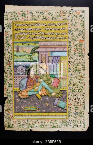 Rajasthani miniature painting from Rajasthan, India.  Probably late 19th century or early 20th century.  A man courts a woman in a boudoir scene. Stock Photo