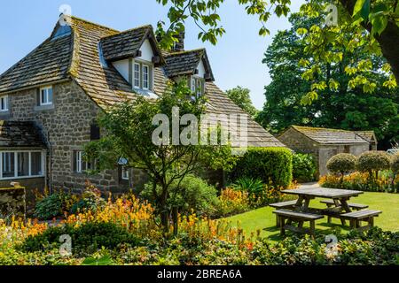 Exterior of quaint attractive cottage tea rooms cafe & country garden flowers, in scenic rural village - Bolton Abbey, Yorkshire Dales, England, UK. Stock Photo