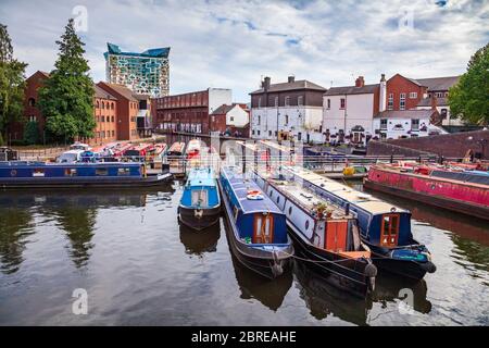 Moored canal barges in Gas Street Basin looking towards the Cube, Birmingham, England Stock Photo