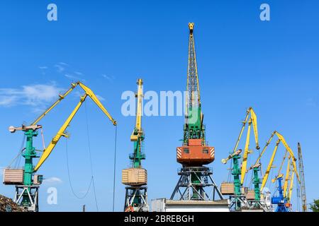 Harbor cranes on blue sky background in Feodosia, Crimea Stock Photo