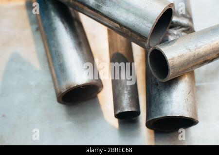 Stainless steel scrap metal, stainless steel pipes on the background of a stainless steel sheet. Close-up. Macro. Stock Photo